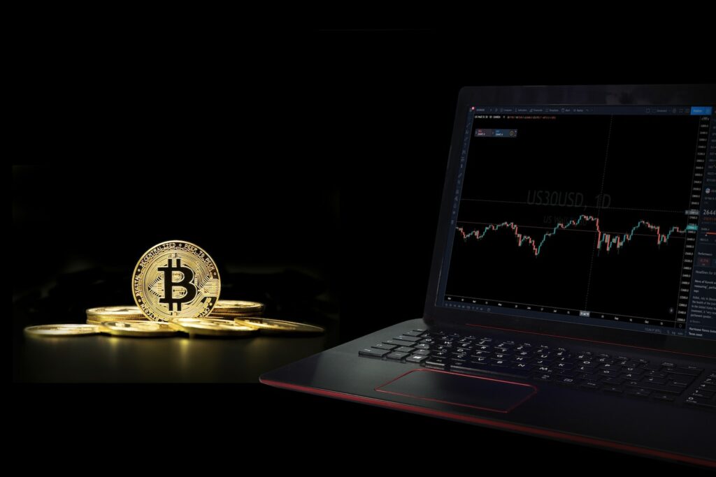 A Laptop Displaying a Graph beside a Commemorative Coin