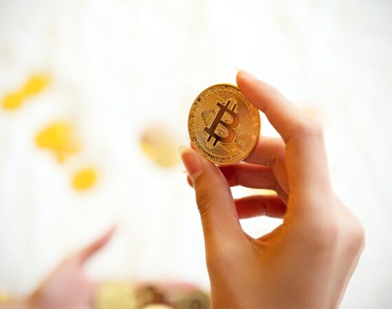 person holding gold round coin