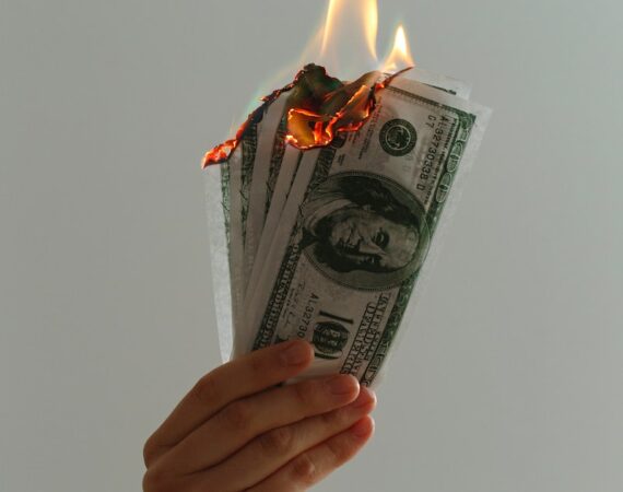 time lapse photography of several burning US dollar banknotes